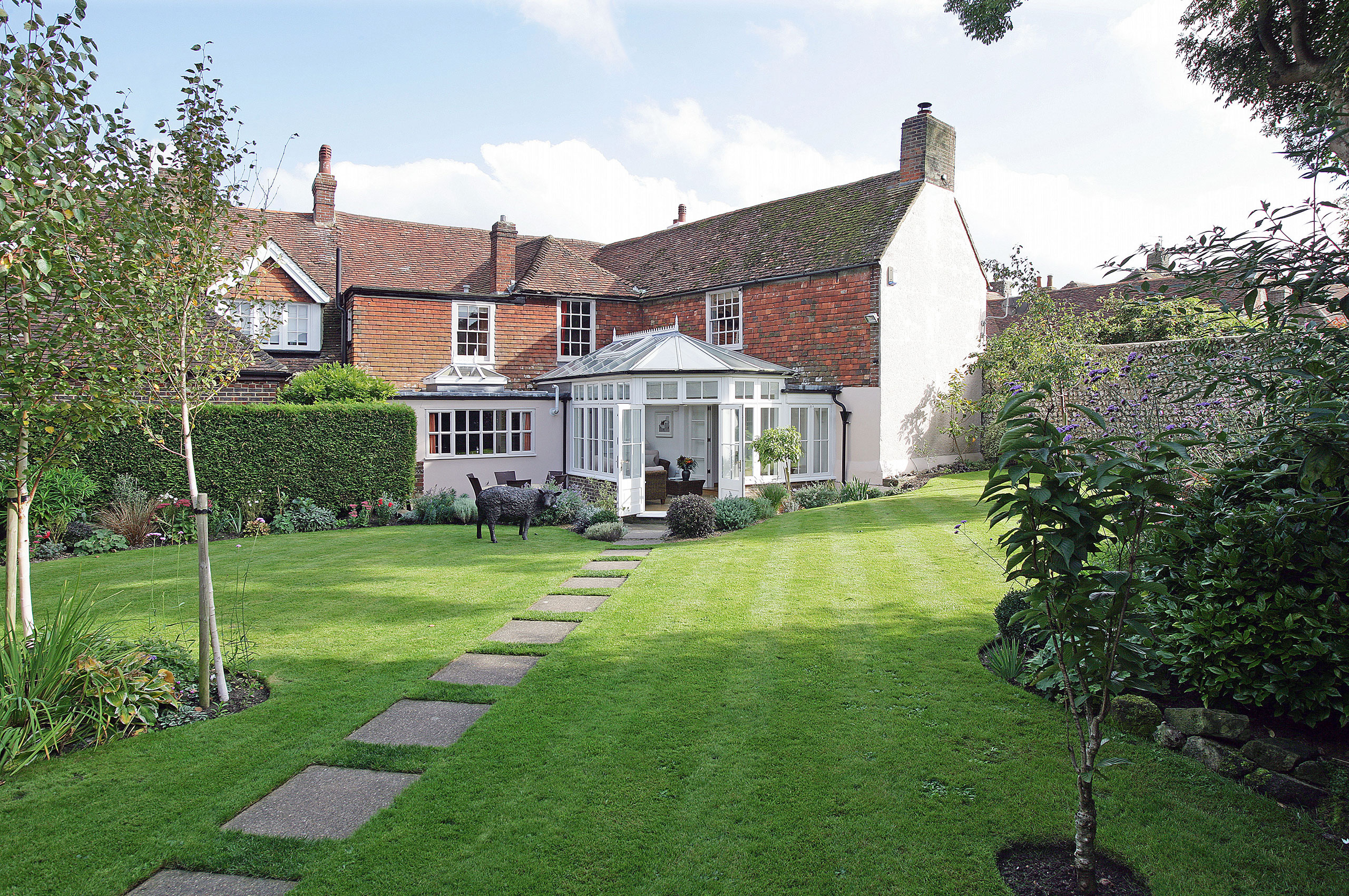 Wide-angle view of The Dene from the garden showing house and conservatory